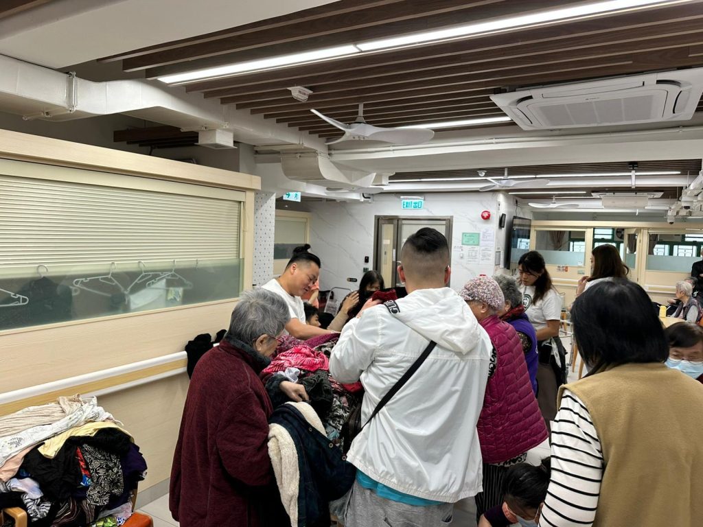 義工們在大埔宏福苑協助長者挑選衣物及分發物資的現場情況。。
