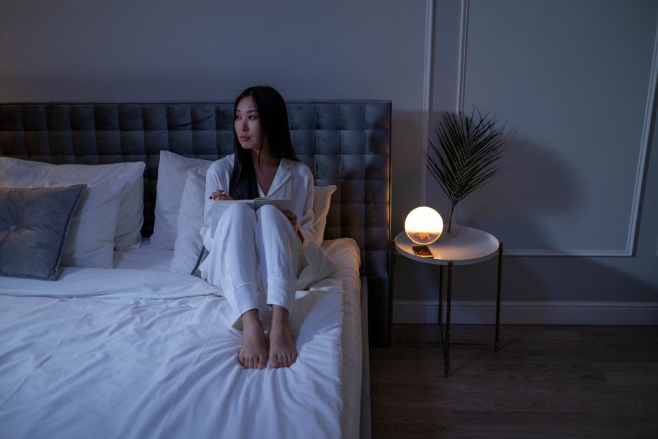床邊夜燈、書本與眼罩在柔和暖光下的靜謐夜間場景