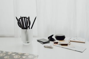 辦公桌與生活物件混合場景：電腦、記事本、眼鏡與咖啡，呈現工作與生活交錯的節奏