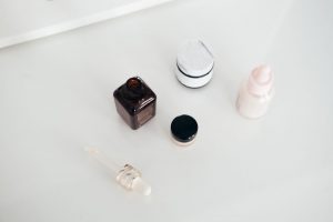 平鋪護膚產品、毛巾與小植物置於木桌上的自然光高級簡潔風格照片