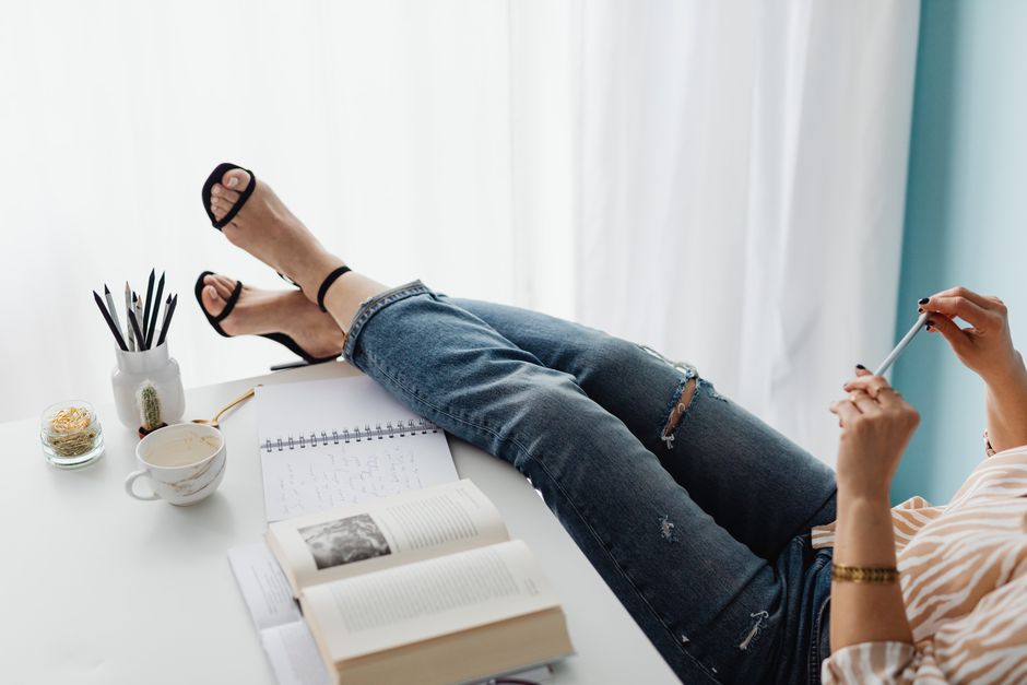 女性在辦公桌旁，桌上有記事本和咖啡，代表工作節奏與時間管理